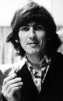 Black-and-white shot of George, in his 20s, with long, dark hair.